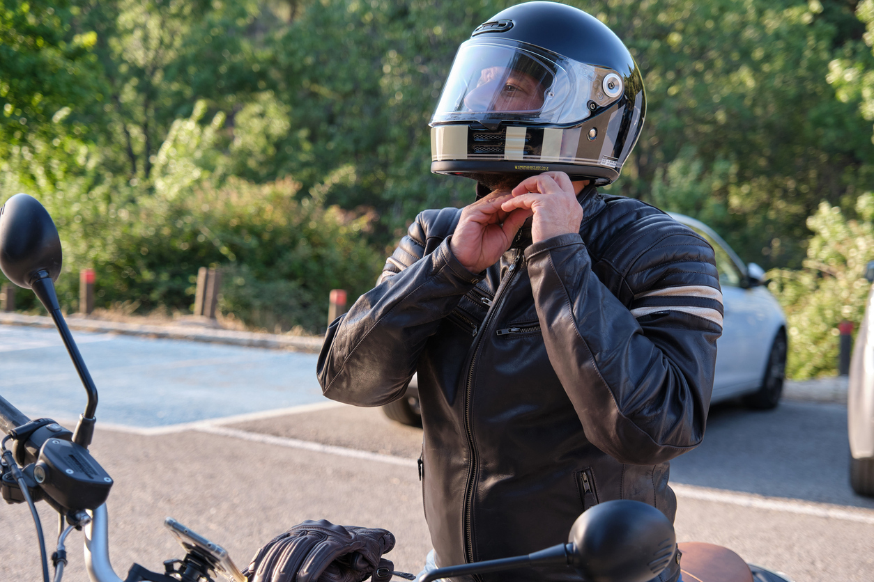 motoryclist putting on helmet