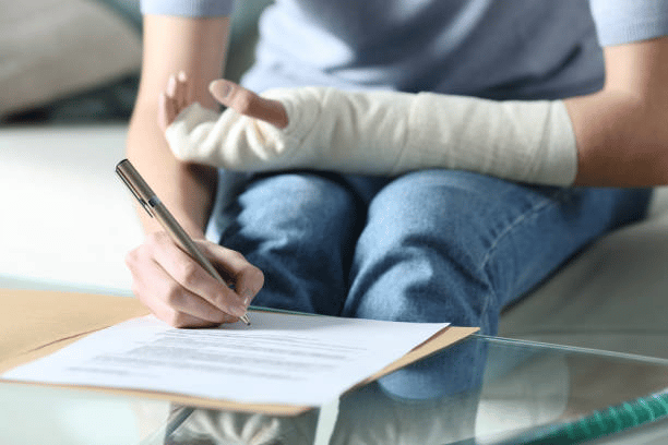 injured person in cast signing legal documents
