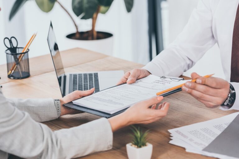 two individuals discussing and signing legal documents