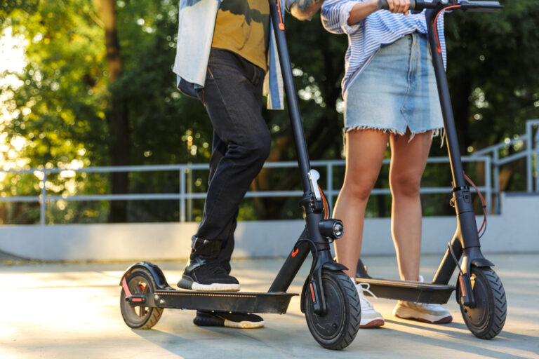 two people riding scooters